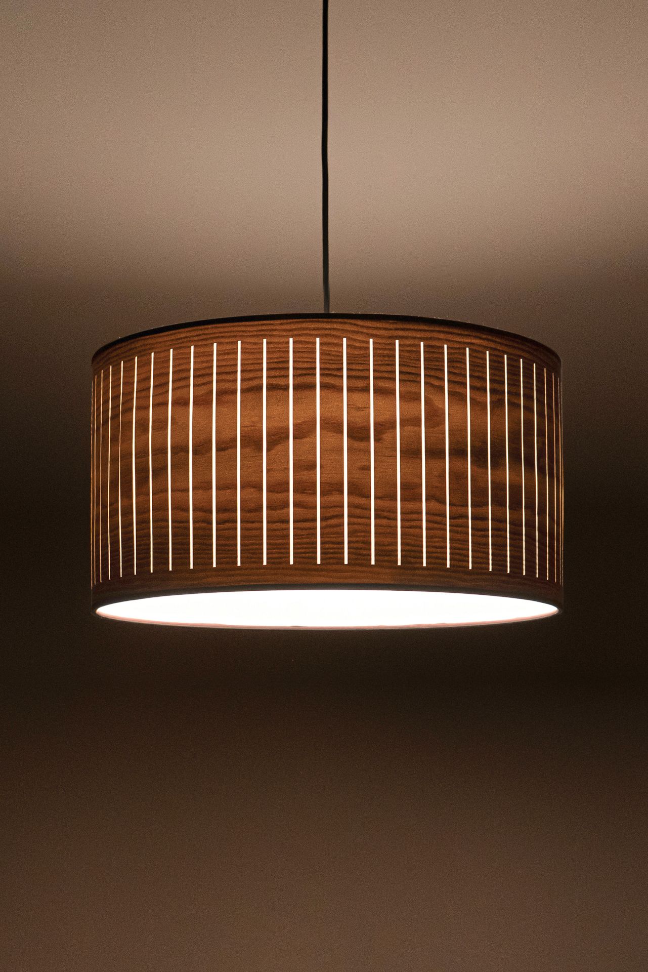 Nomon Autumn Pendelleuchte: Moderne Hängelampe aus Holz mit vertikalen Lichtschlitzen für stimmungsvolle Beleuchtung.