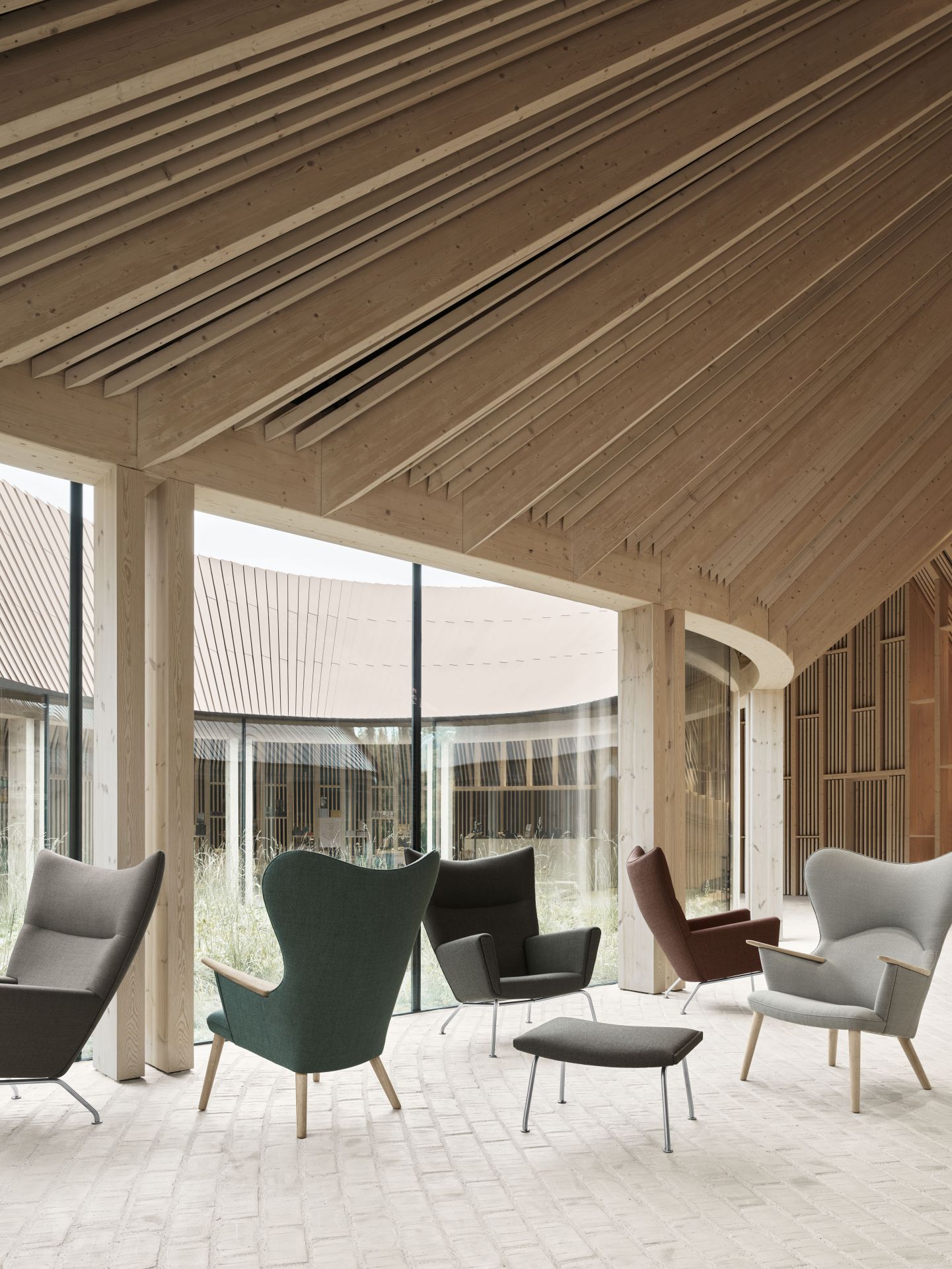 CH445 Sessel von Carl Hansen & Søn in verschiedenen Farben und mit Fußhocker in modernem Raum.