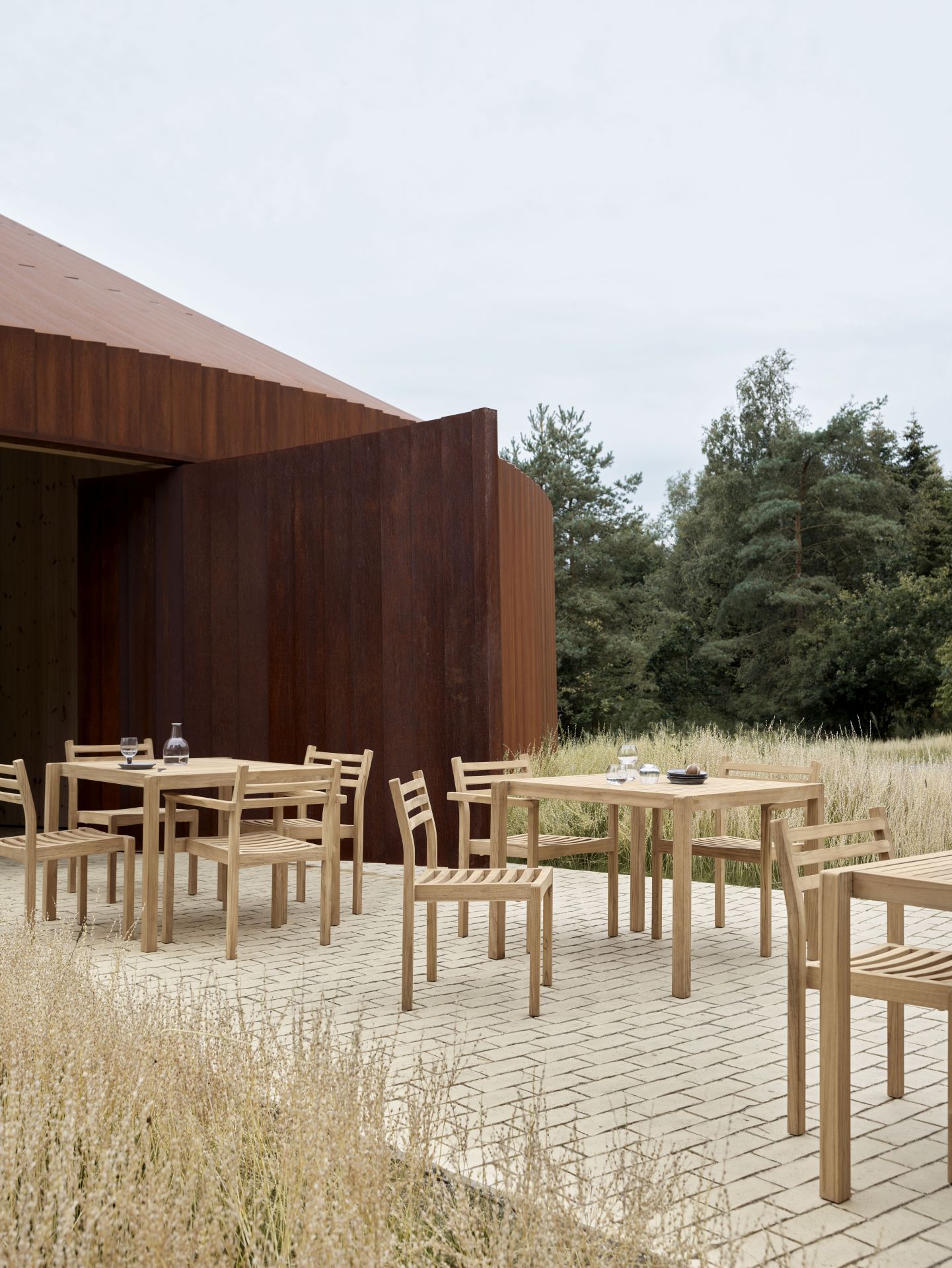 AH902 Esstisch Outdoor von Carl Hansen & Søn aus Holz mit Stühlen auf Terrasse.