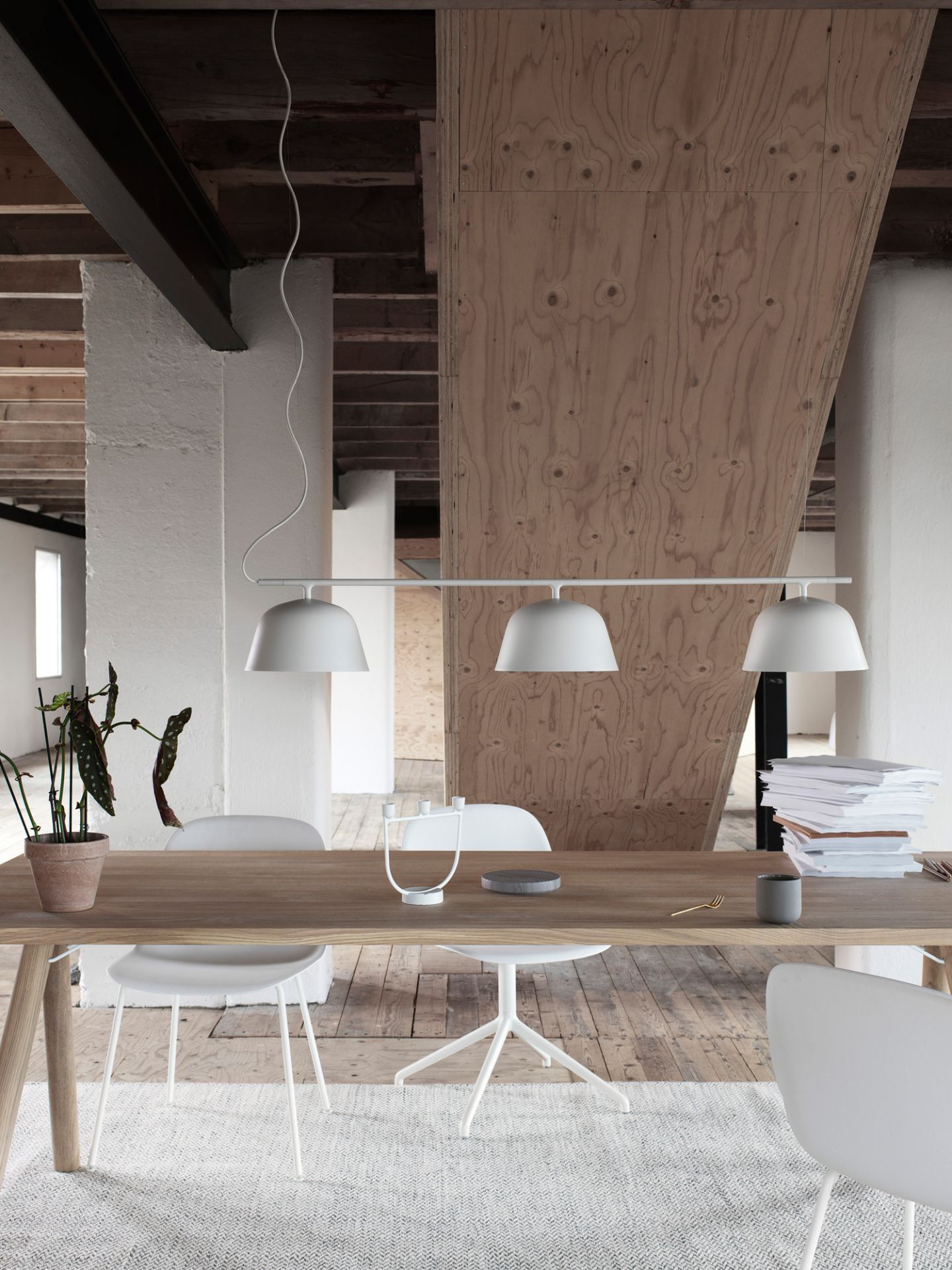 Heller Raum mit Holztisch und weißen Fiber Side Chairs von Muuto mit Drehfuß.