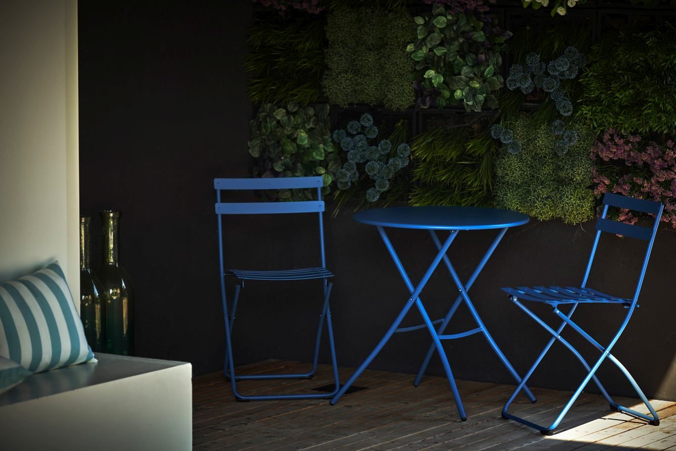 Blauer Fiam Sirio Klapptisch und Stühle von Jan Kurtz für den Outdoor-Bereich auf Holzterrasse.