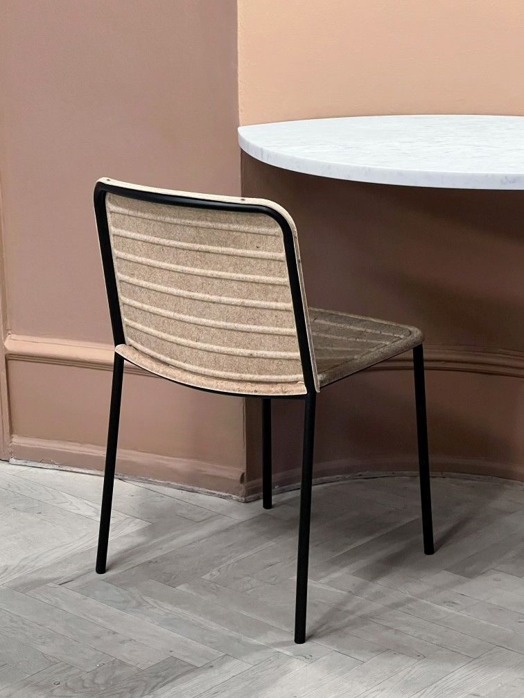 Flax Stacker Chair: Moderner Stuhl mit schwarzem Gestell und beiger Sitzfläche aus Flachs.