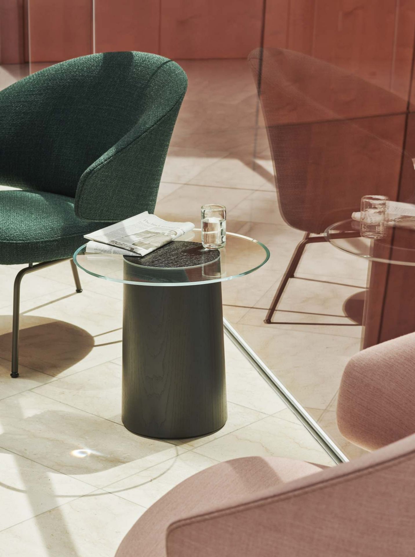 Nahaufnahme von Fritz Hansen Let Sessel in Grün mit passendem Beistelltisch, modernes Wohnzimmer-Interieur.