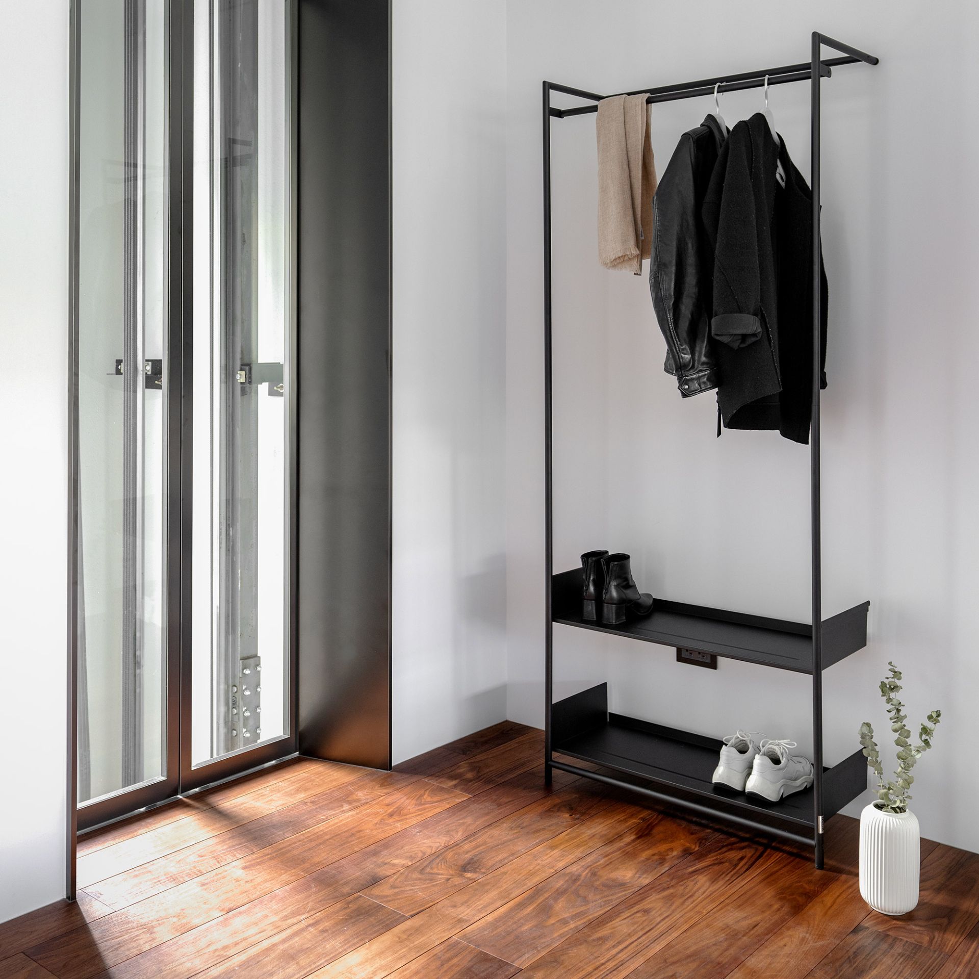 Comba Anlehngarderobe von Mox, modernes Design mit schwarzem Metallgestell, Ablagen für Schuhe und Kleiderstange für Jacken.