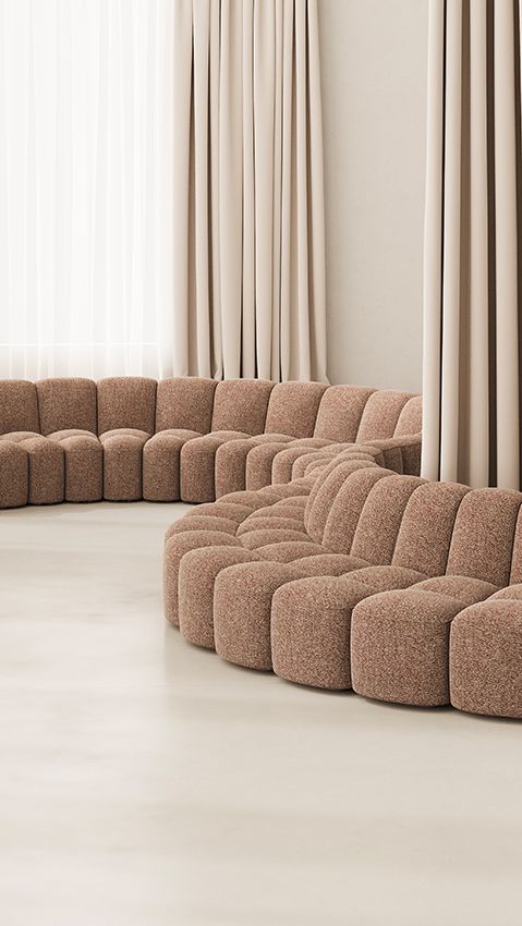 Nahaufnahme des Array Sofa Systems von MDF Italia, ein modulares Sofa in Bouclé-Optik, beige Vorhänge im Hintergrund.