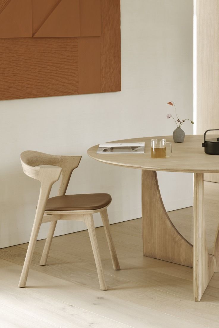 Ethnicraft Geometric Dining Table aus Eiche mit Stuhl und Deko auf Holzboden.