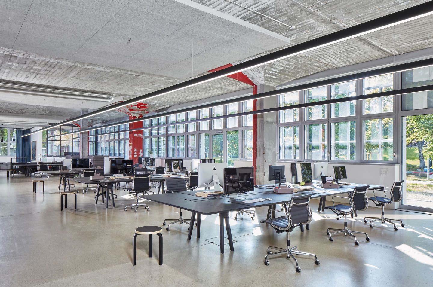 Offenes Büro mit Schreibtischen und Vitra Aluminium Chair EA 119 Bürostühlen mit hoher Rückenlehne.