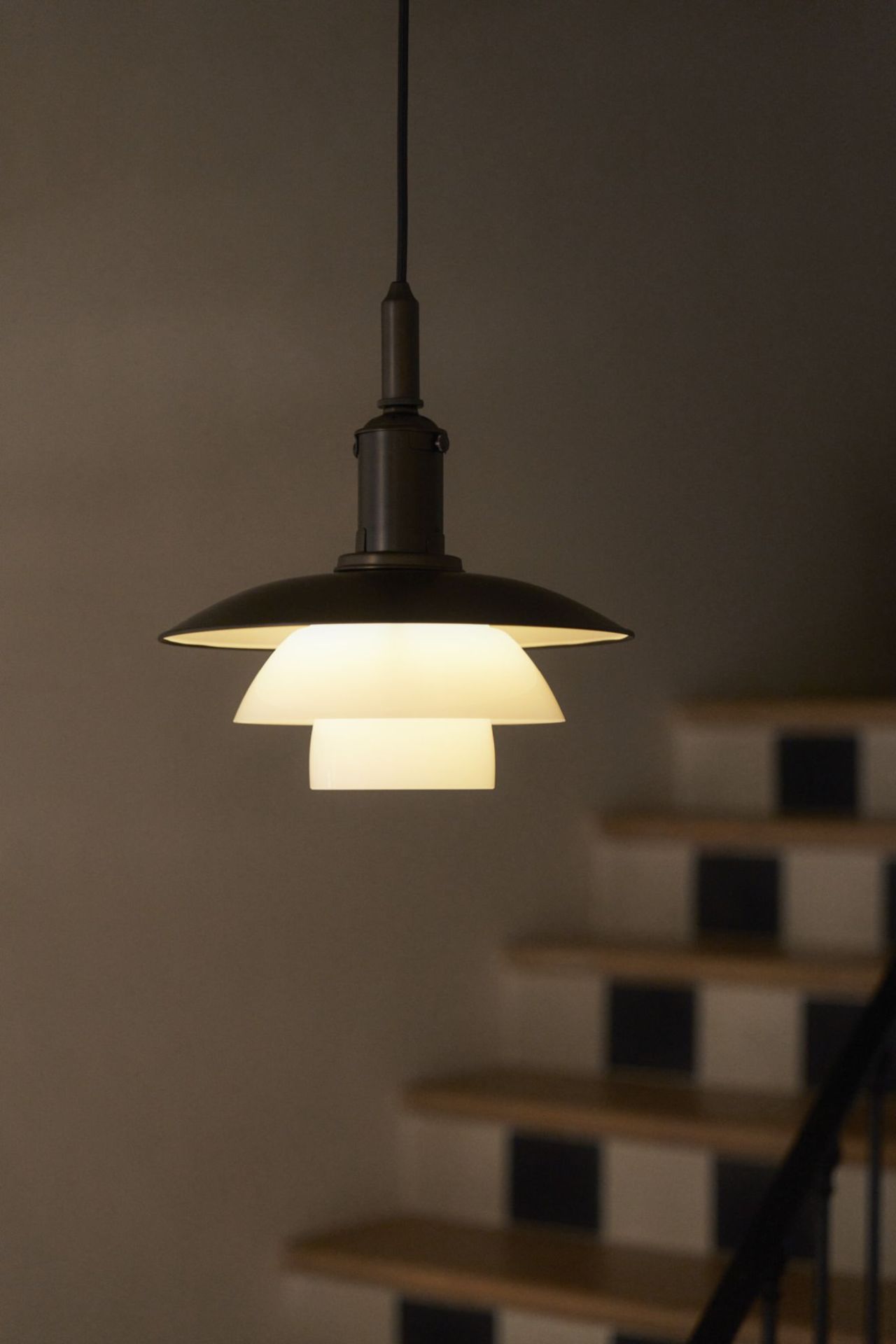 Nahaufnahme der Louis Poulsen PH 3/3 Pendelleuchte aus Messing und Opalglas, modernes skandinavisches Design.