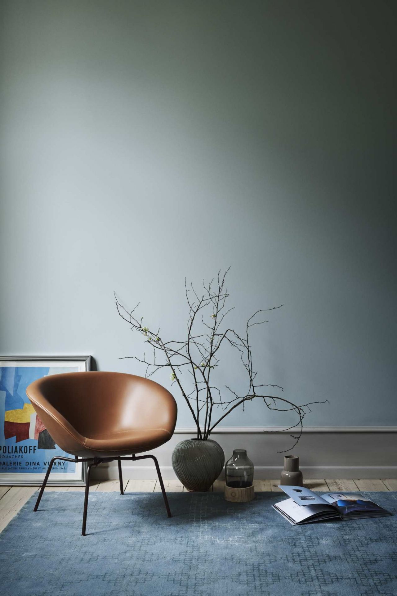Brauner Fritz Hansen Pot Sessel aus Leder im Interieur mit Teppich und Dekoration.