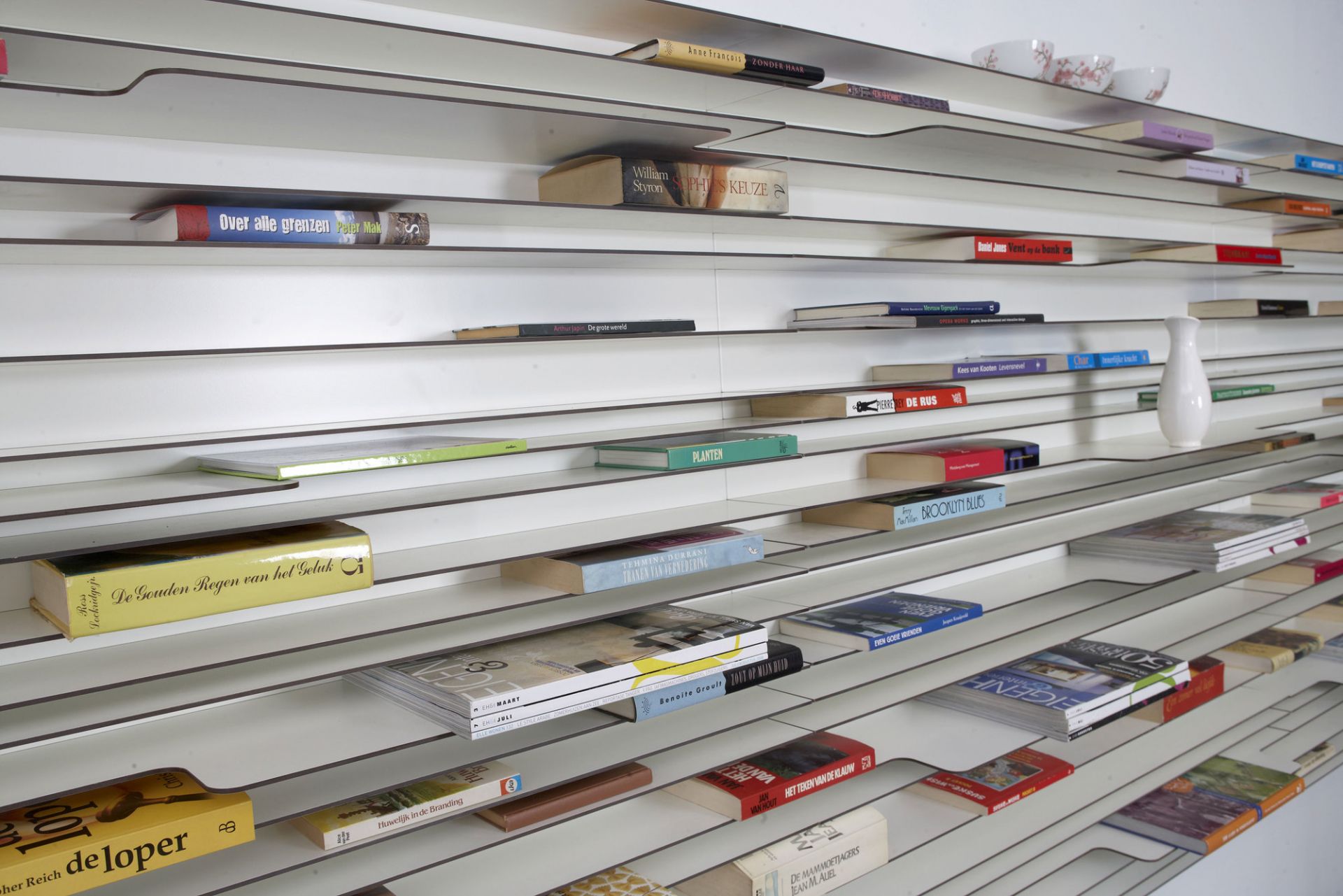 Anthrazitfarbenes Bücherregal mit Büchern. Das moderne Wandregal bietet viel Stauraum für Bücher und Deko.