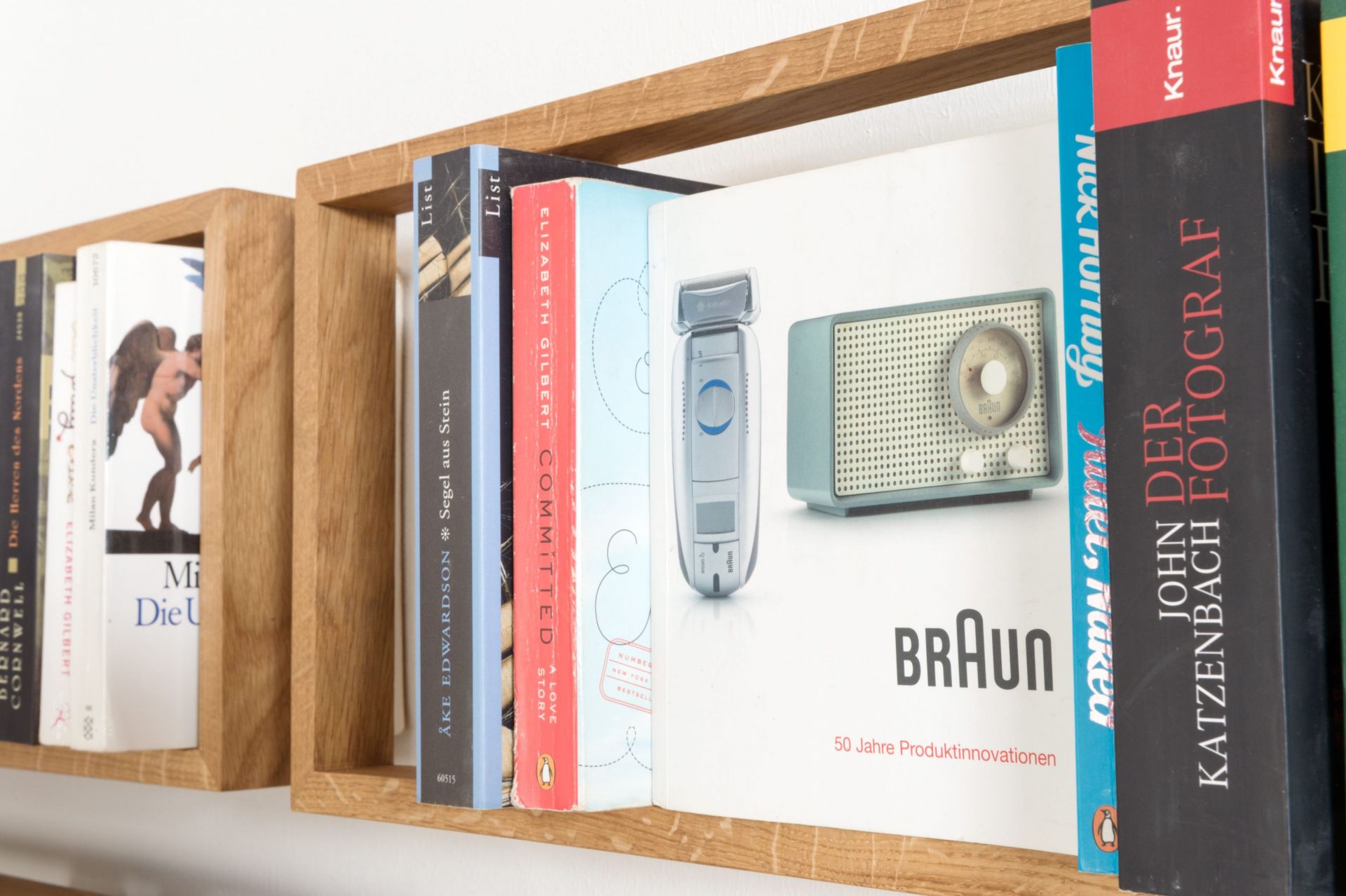 Nahaufnahme des Regal b Eiche das kleine b EINZELSTÜCK, gefüllt mit Büchern und einer Braun-Werbeanzeige.