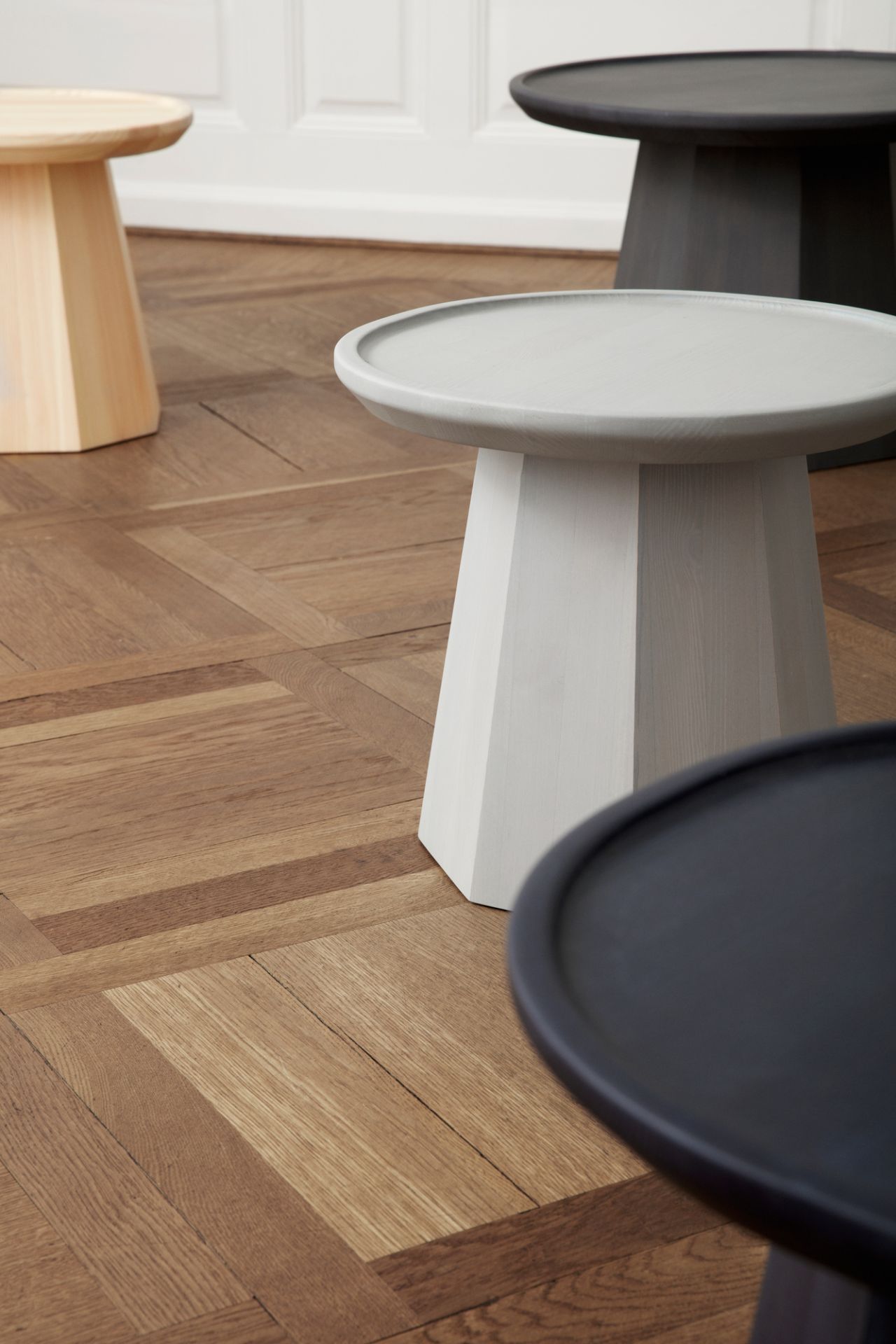 Nahaufnahme von mehreren Pine Table Beistelltischen von Normann Copenhagen in verschiedenen Farben.