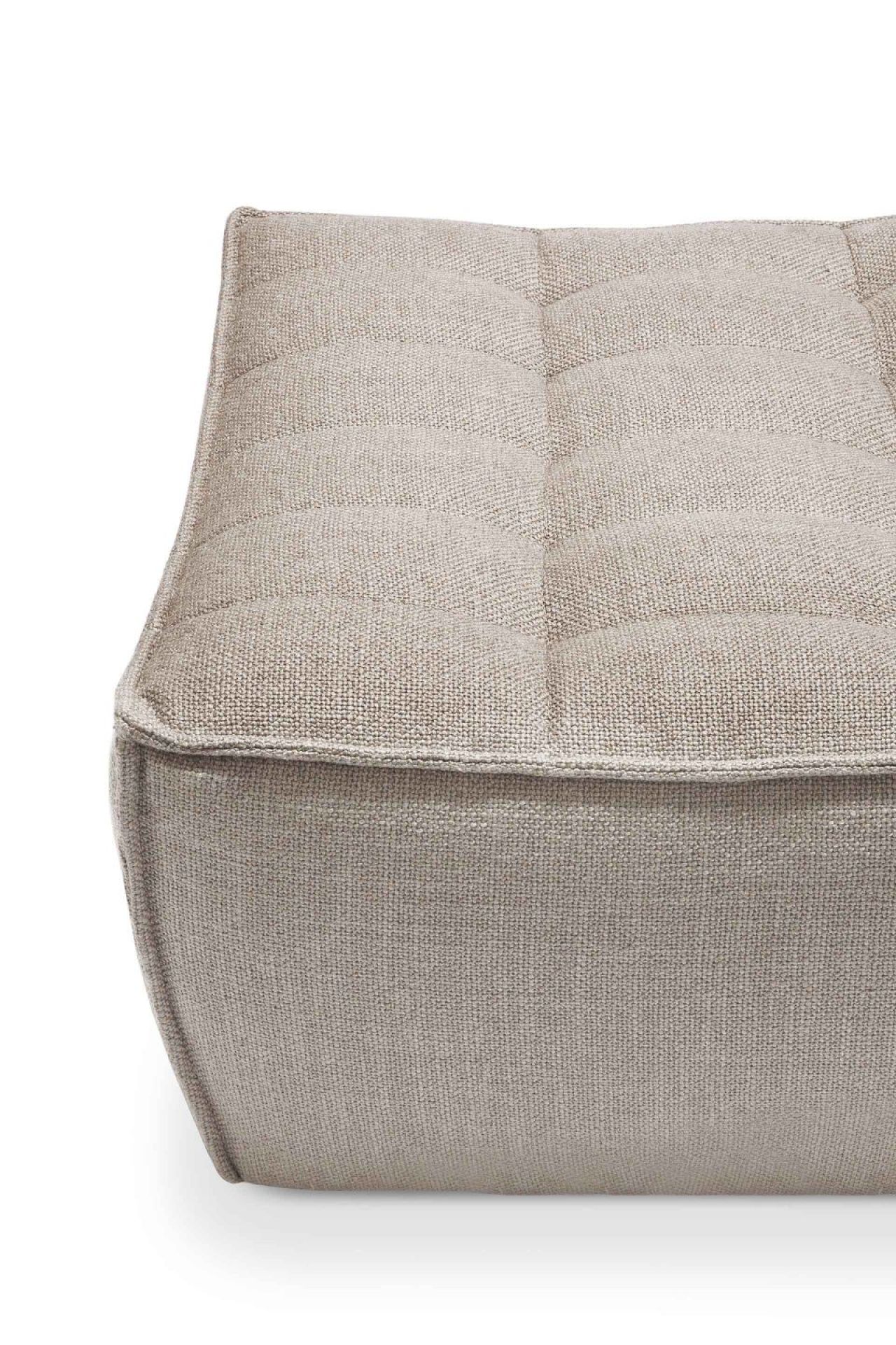 Detailaufnahme des Ethnicraft N701 Polsterhockers: Beige Textur, gesteppte Oberfläche, hochwertiges Design für Wohnzimmer.
