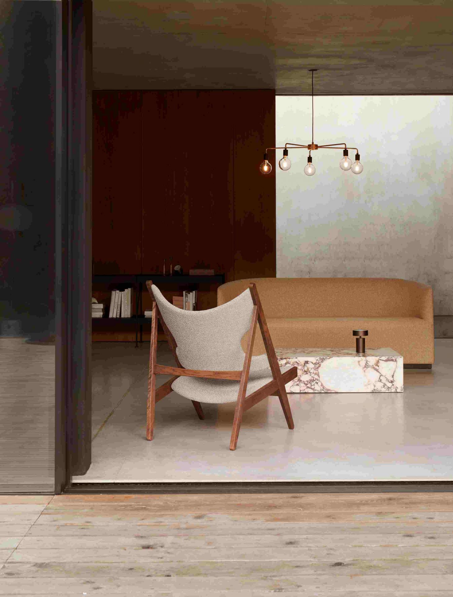 Audo Plinth Beistelltisch aus weißem Carrera Marmor in modernem Wohnzimmer mit Sessel und Sofa.