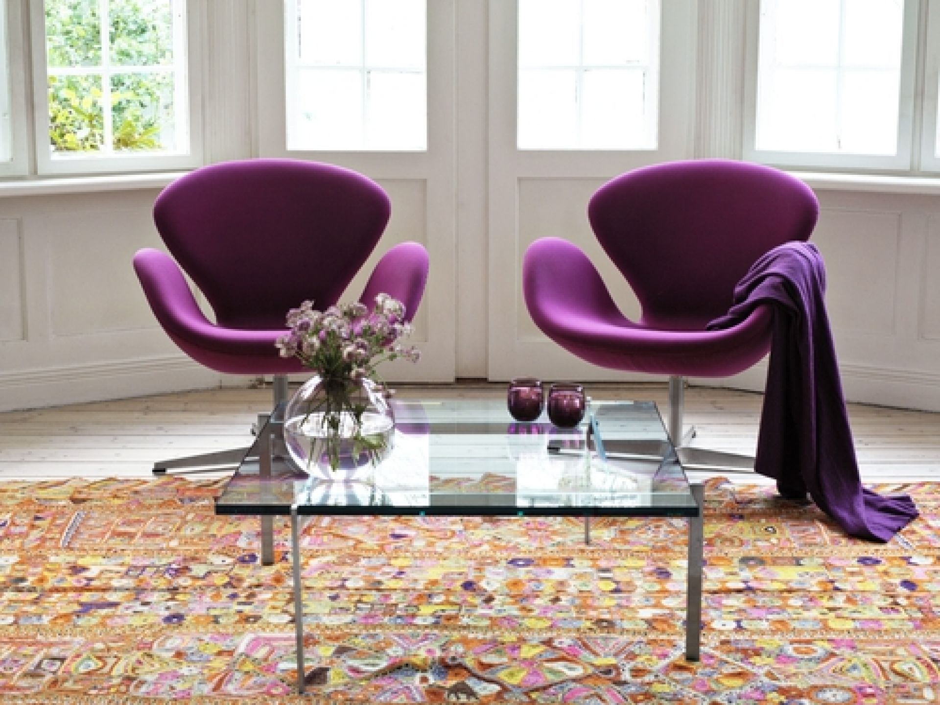 Zwei lila Swan Sessel von Fritz Hansen in einem hellen Wohnzimmer mit Teppich.