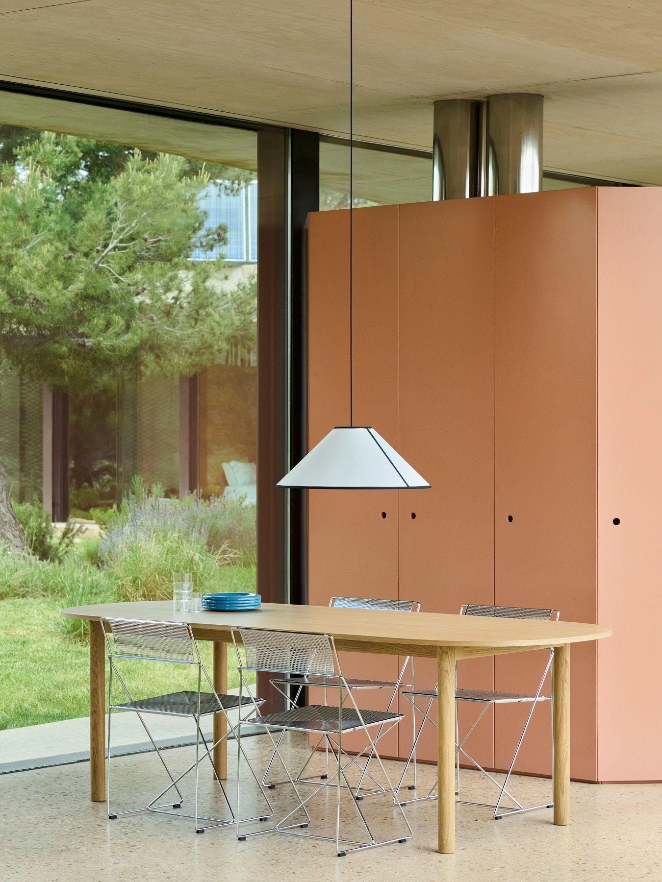 Weiße Hay Ava Cone Pendelleuchte über Esstisch mit Stühlen in modernem Interieur.