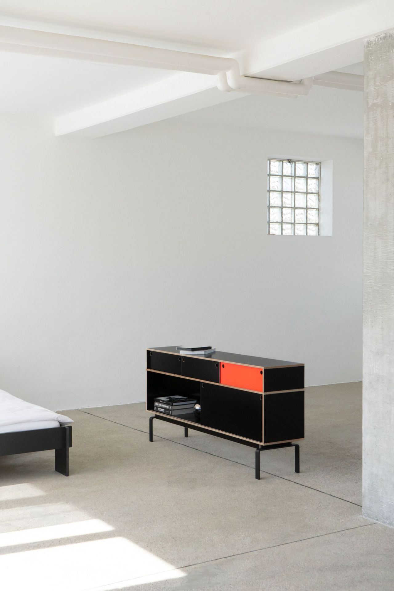 Egal Sideboard von Nils Holger Moormann, schwarz mit orangefarbener Tür, modernes Designmöbel für Wohnzimmer.