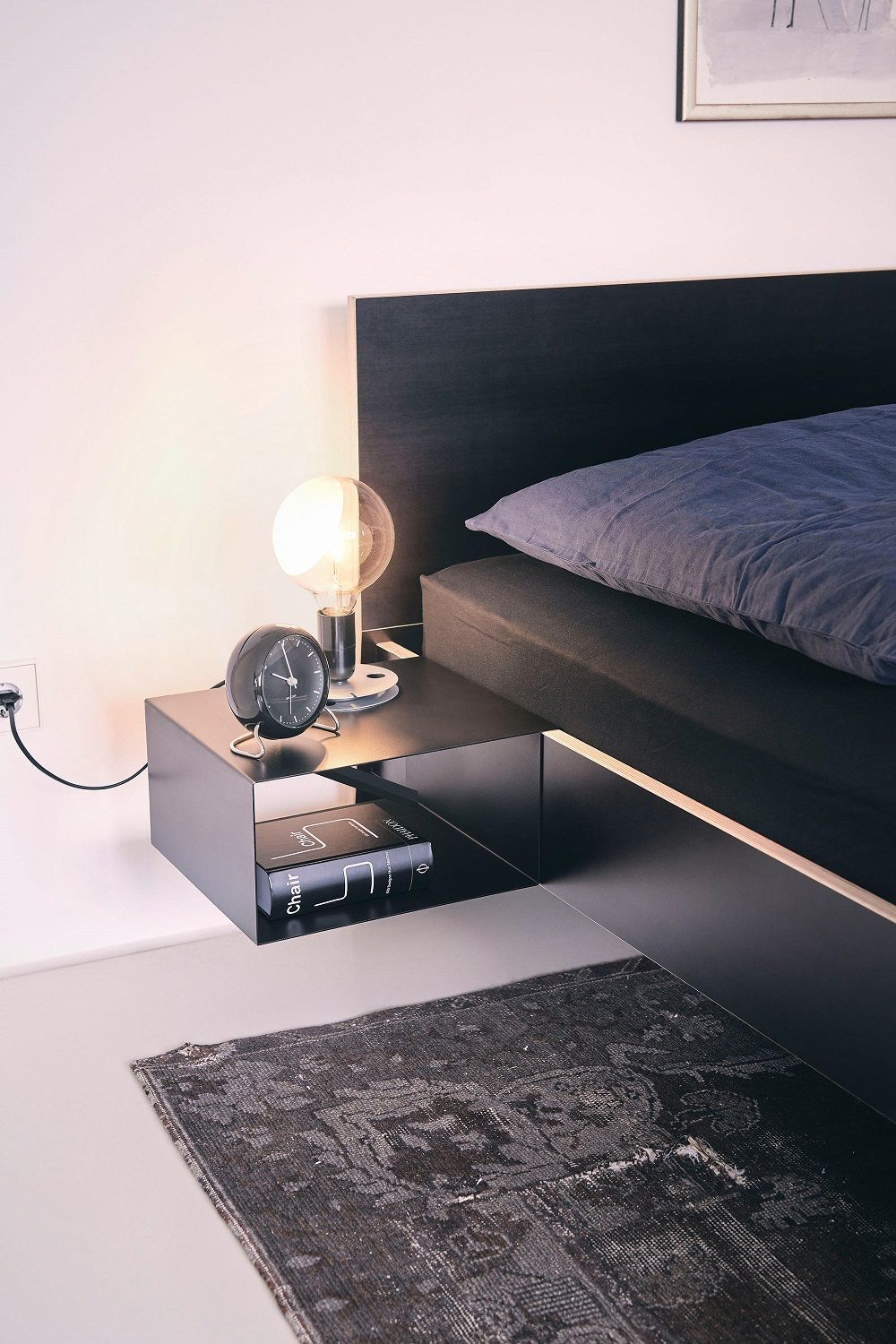 Schwarzer Nachttisch zum Einhängen am Bett mit Lampe und Wecker. Stockholm Bett Nachttisch.