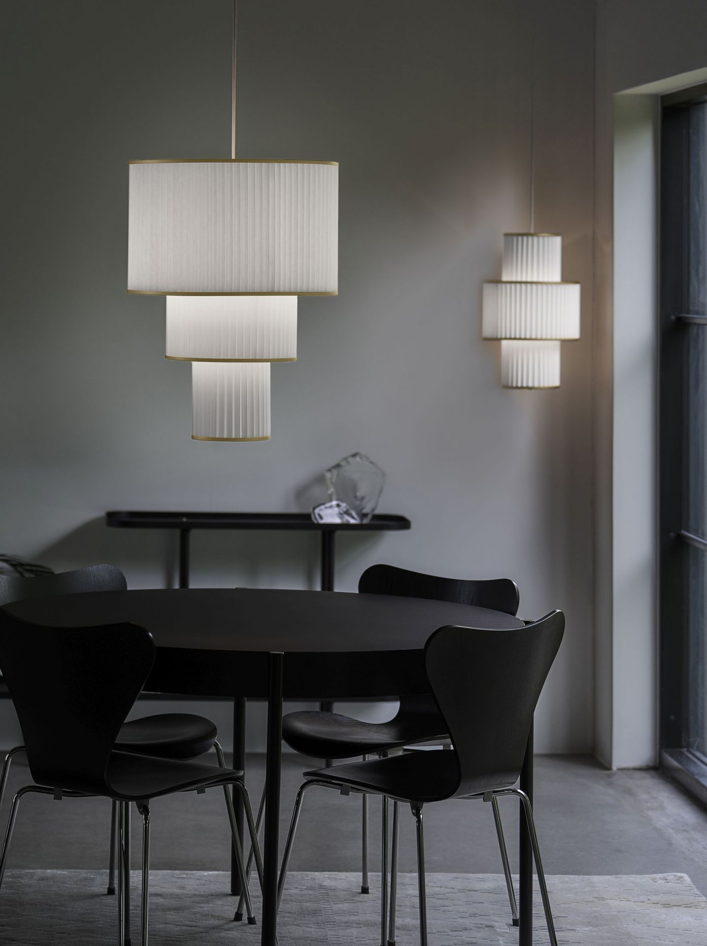 Plivello Pendelleuchte von Le Klint über Esstisch mit Stühlen, moderne Hängeleuchte mit plissiertem Lampenschirm.