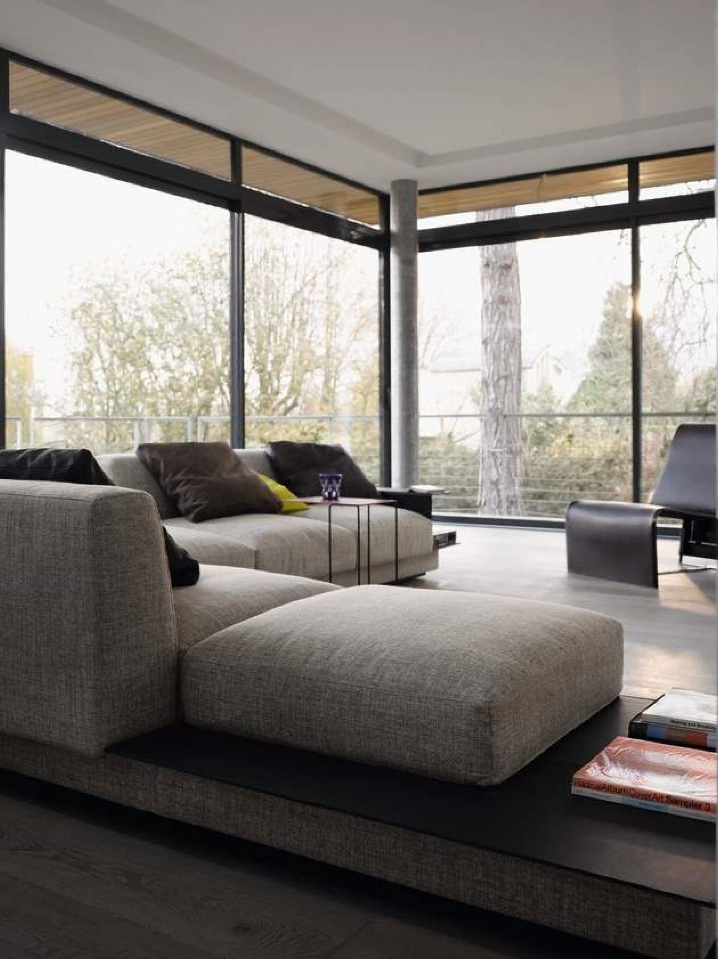 Moderner Wohnraum mit Walter Knoll Oki Beistelltisch in Schwarz neben einem grauen Sofa.