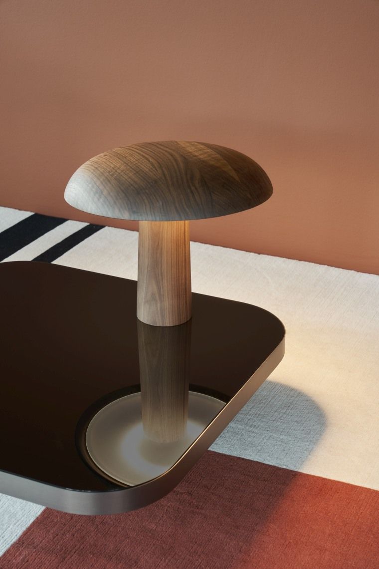 Bow Coffee Table von ClassiCon, Couchtisch mit dunkler Glasplatte und Holz-Pilzlampe als Dekoration.