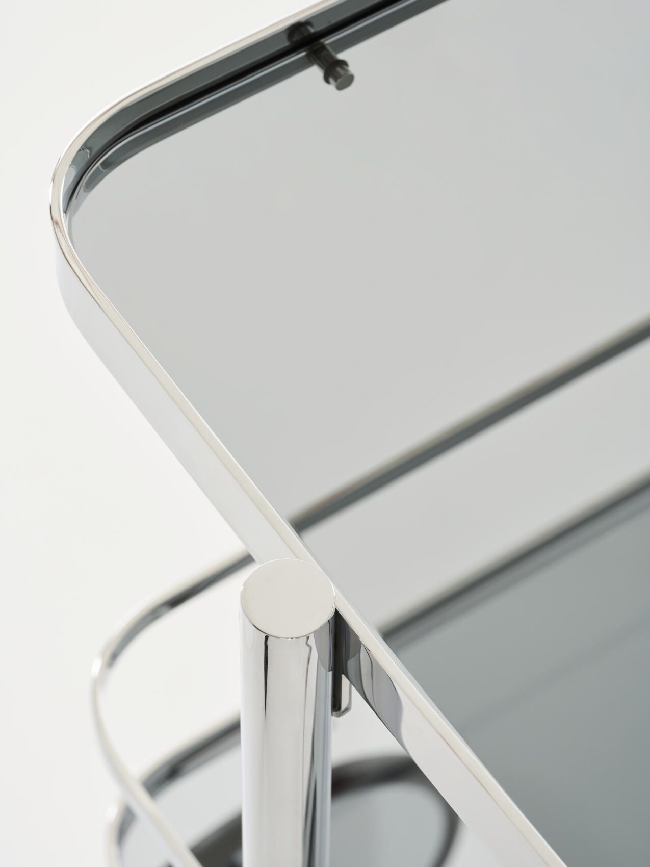 Detailaufnahme vom Thonet S 179 Barwagen mit verchromtem Stahlrohr und Glasablagen, modernes Design.