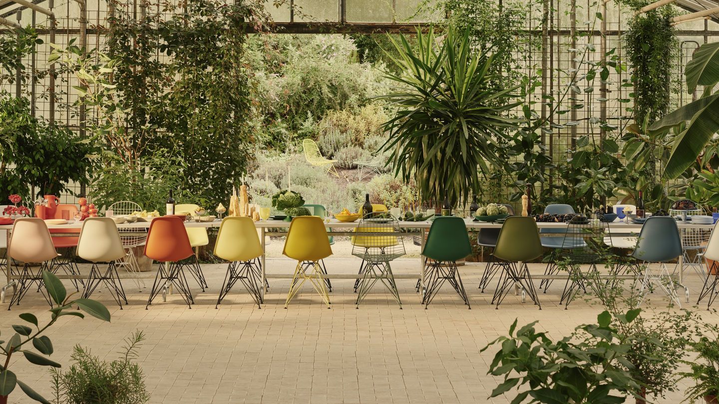 Eames Plastic Side Chair DSR Stühle von Vitra in verschiedenen Farben an langem Esstisch.