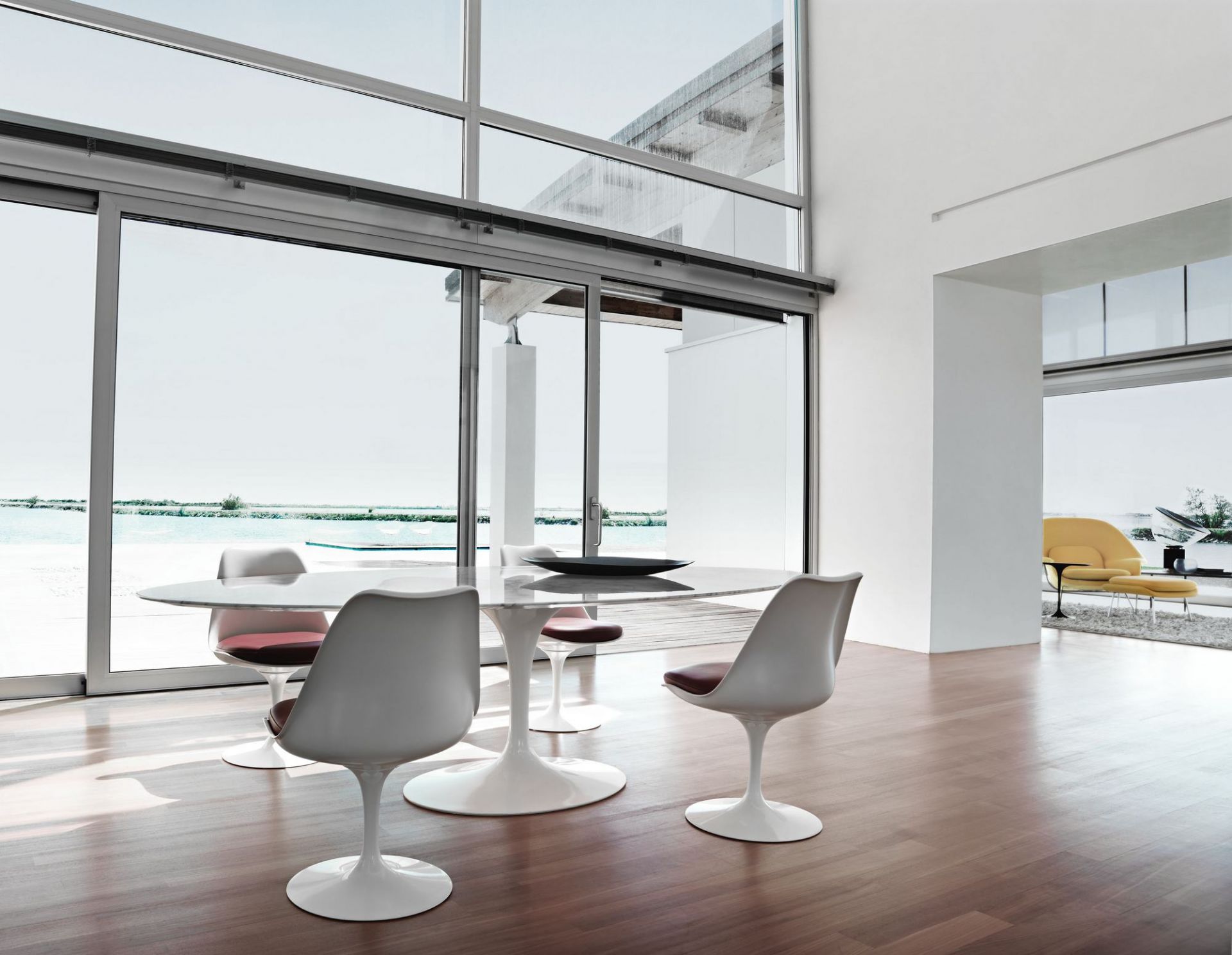 Esszimmer mit Marmortisch und vier weißen Tulip Chair Stühlen von Knoll International mit braunen Sitzkissen.