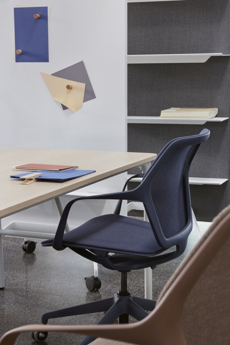 Brunner Ray Work Bürodrehstuhl in Blau vor Schreibtisch und Regal, ergonomischer Arbeitsplatzstuhl mit Armlehnen.