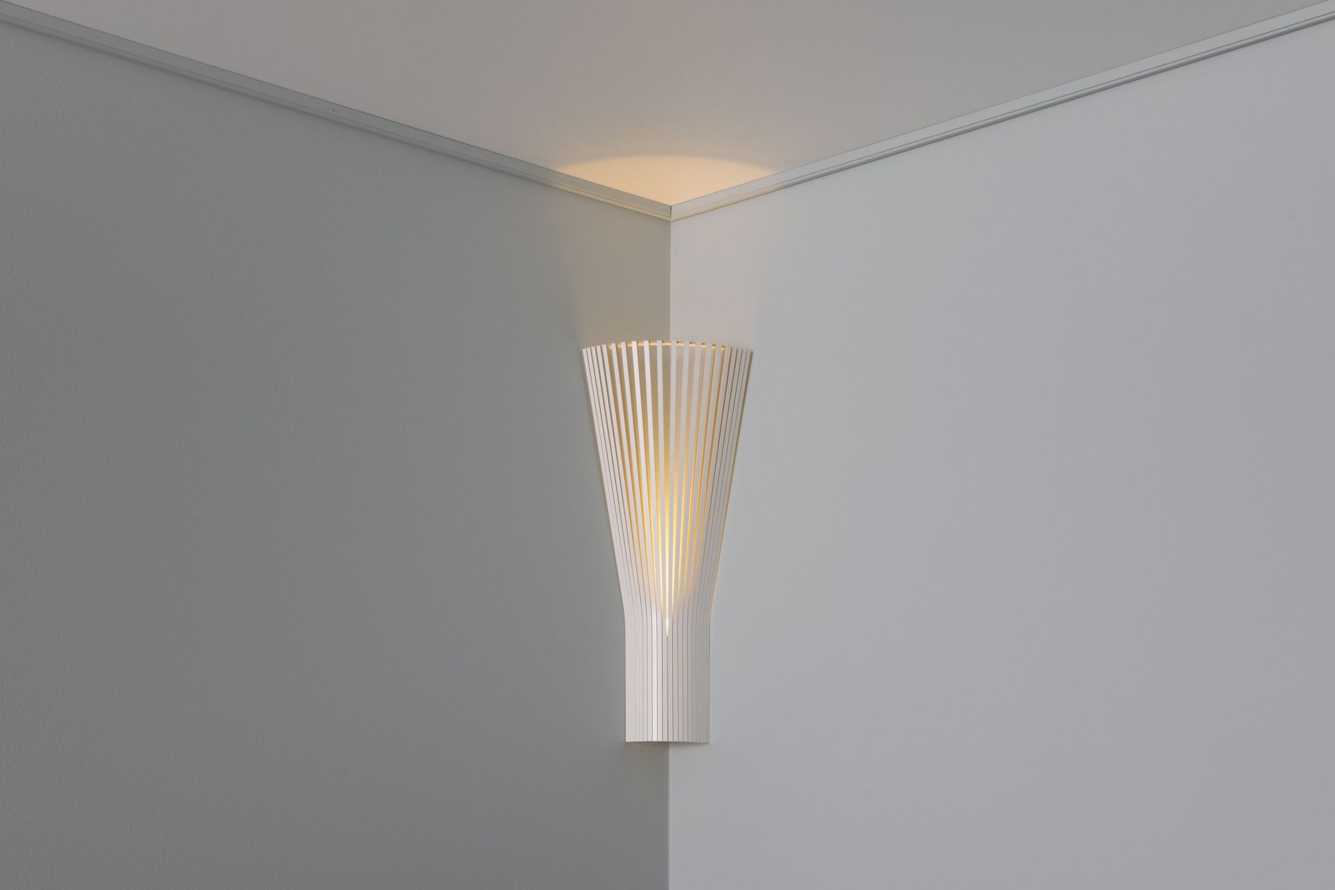 Secto Design Eckleuchte 4236 aus Birke, weiß laminiert, spendet warmes Licht in der Ecke.