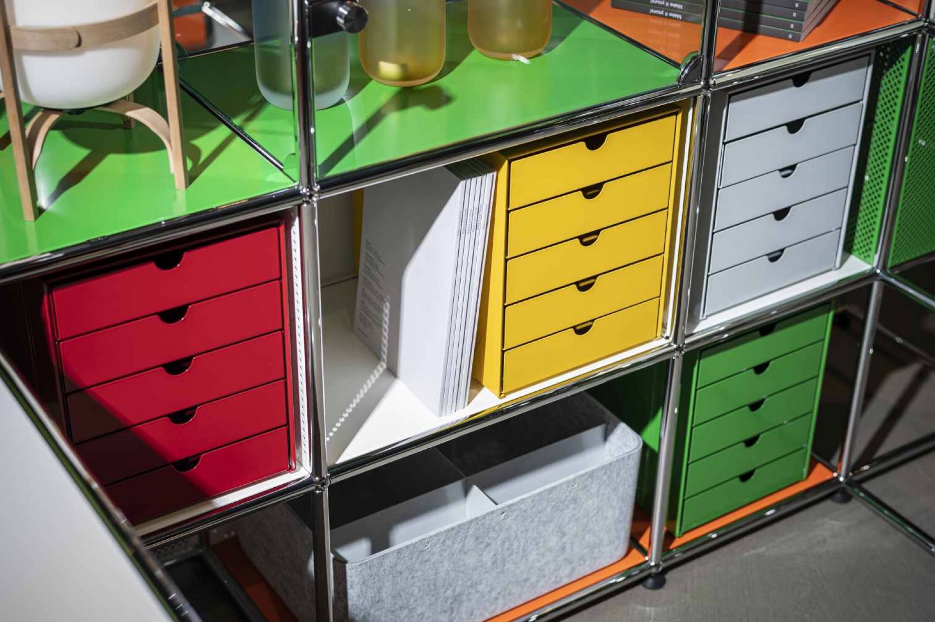 Detailaufnahme von USM Haller Möbelbausystem mit Inos Kastensets in Goldgelb, Rot, Grün und Grau für Büro und Home Office.