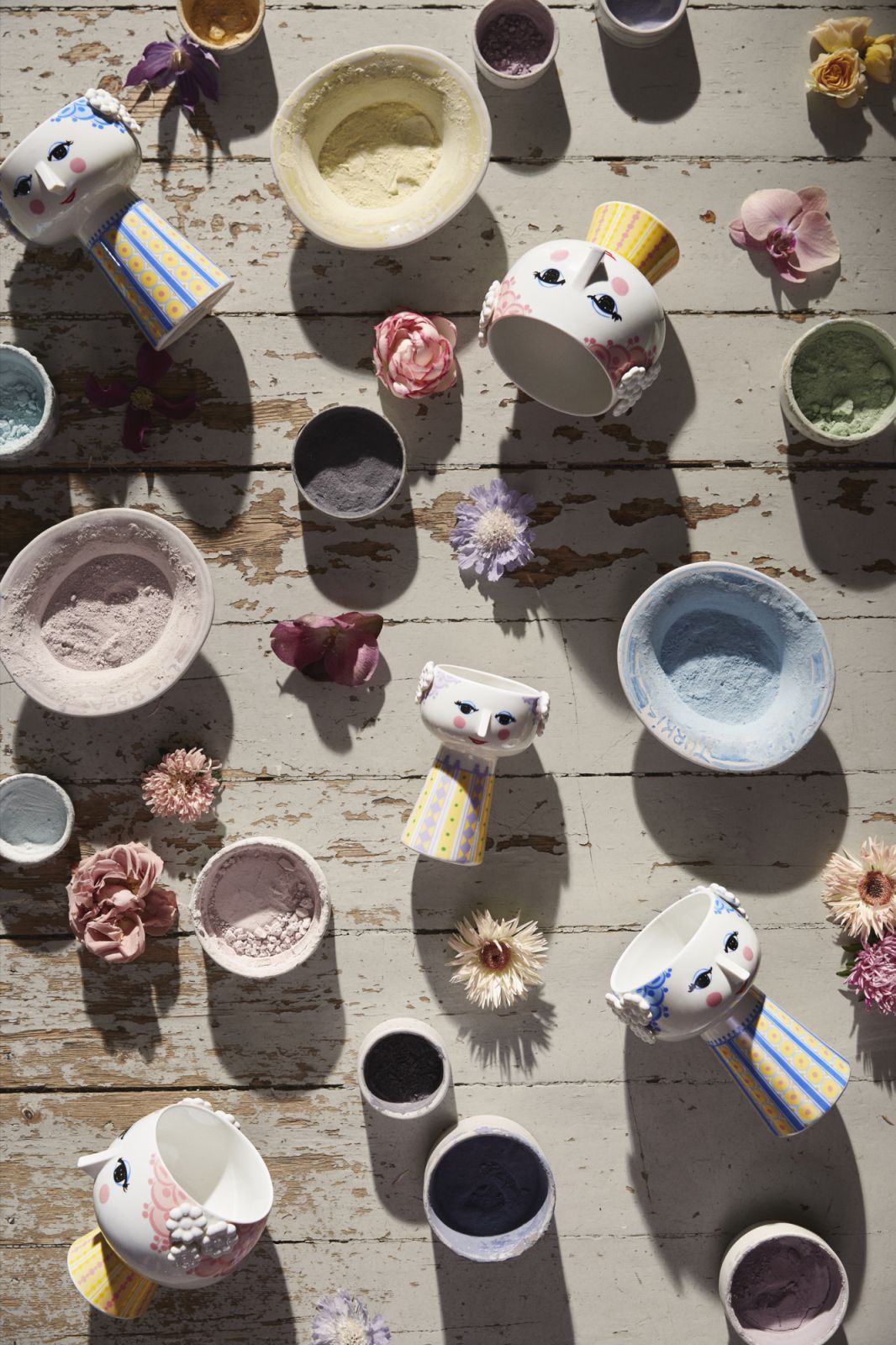 Produktfoto: Mehrere Bjørn Wiinblad Eva Vasen H15cm Lavendel und kleine Schalen mit farbigem Inhalt auf Holztisch.