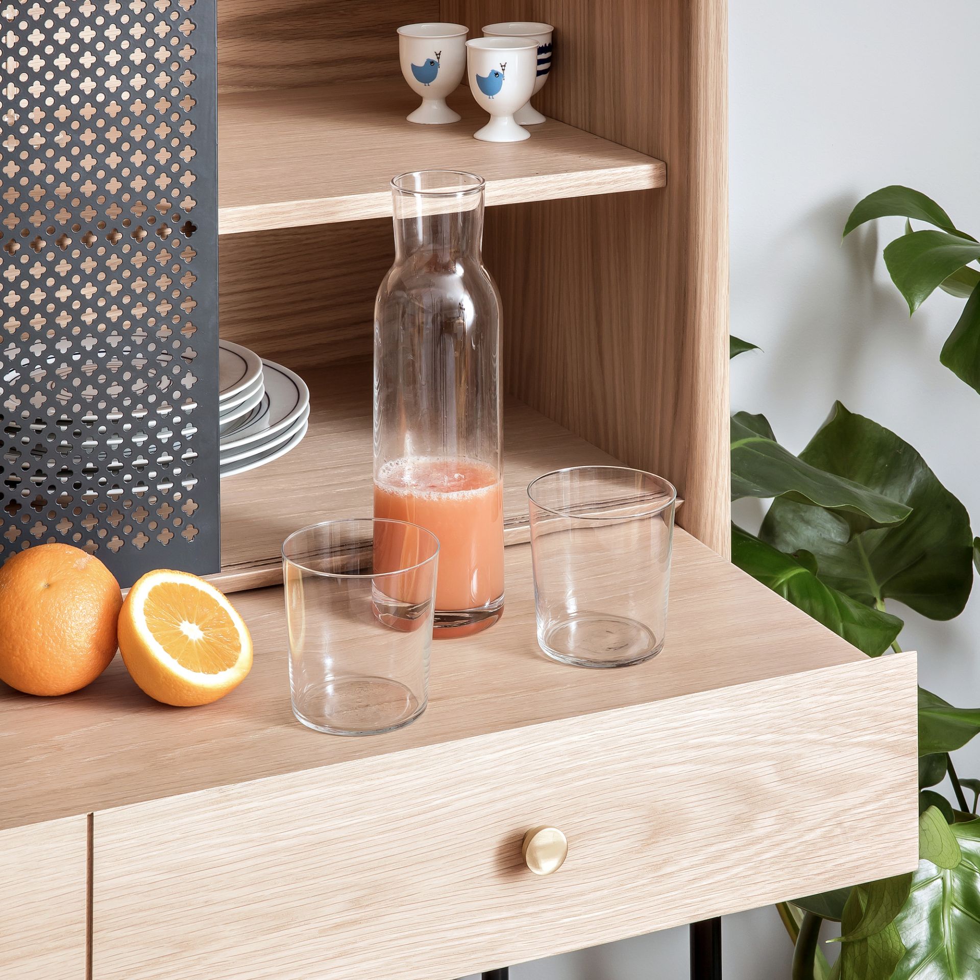 Gabin Cabinet Anrichte aus hellem Holz mit Getränken und Orangen dekoriert, modernes Möbeldesign für Wohnzimmer.