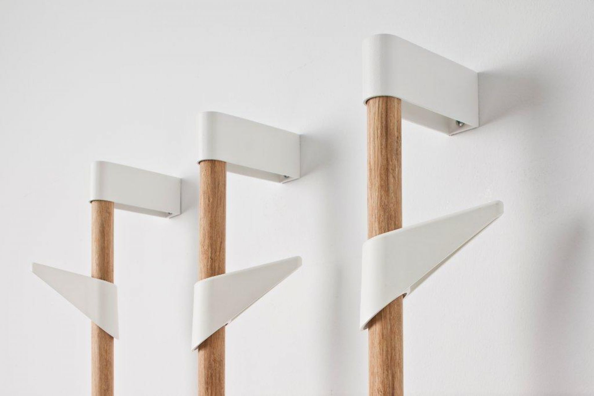 Cascando Bamboo Wandgarderobe mit drei Holzelementen und weißen Haken an einer weißen Wand.