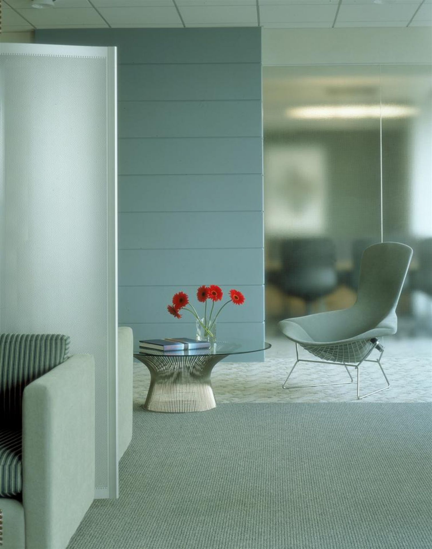 Platner Beistelltisch von Knoll International mit Glasplatte und Blumen in modernem Büro-Ambiente.