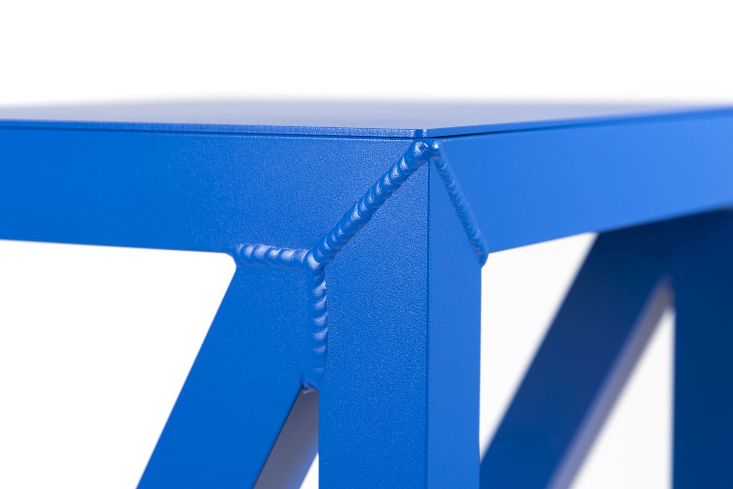 Detailaufnahme des blauen Bureaurama Hocker-Gestells aus Metall, das die Schweißnähte und die X-förmige Konstruktion zeigt.