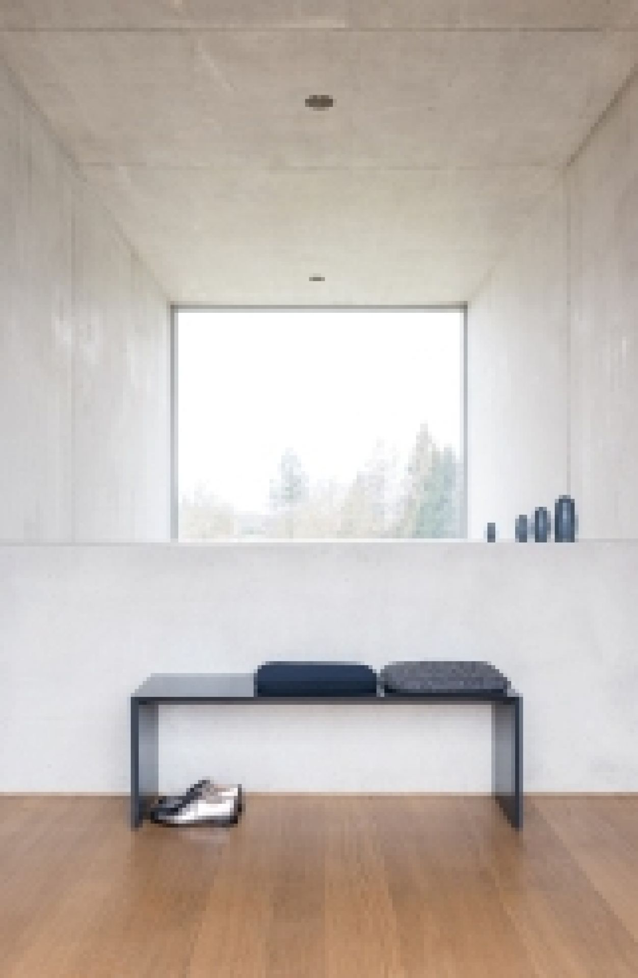 Schwarze Schönbuch Sitzbank mit Kissen vor Fenster, minimalistisches Design für Flur und Eingangsbereich.