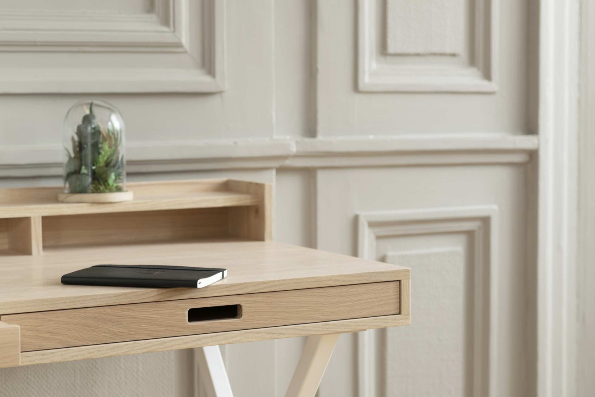 Hyppolite Sekretär aus hellem Holz mit Schublade, Notizbuch und Dekoration unter Glasglocke.