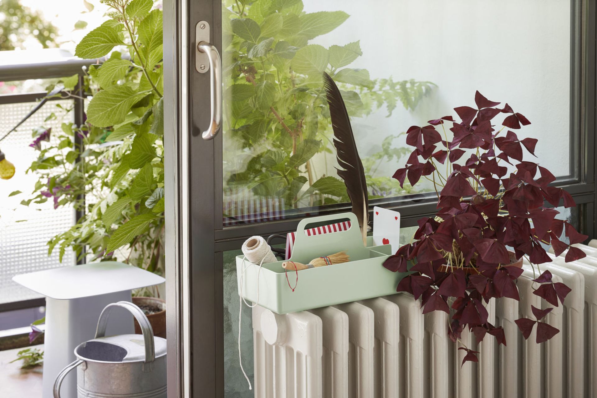 Vitra Metal Side Table Beistelltisch in Weiß auf Balkon mit Pflanze und Dekoration.