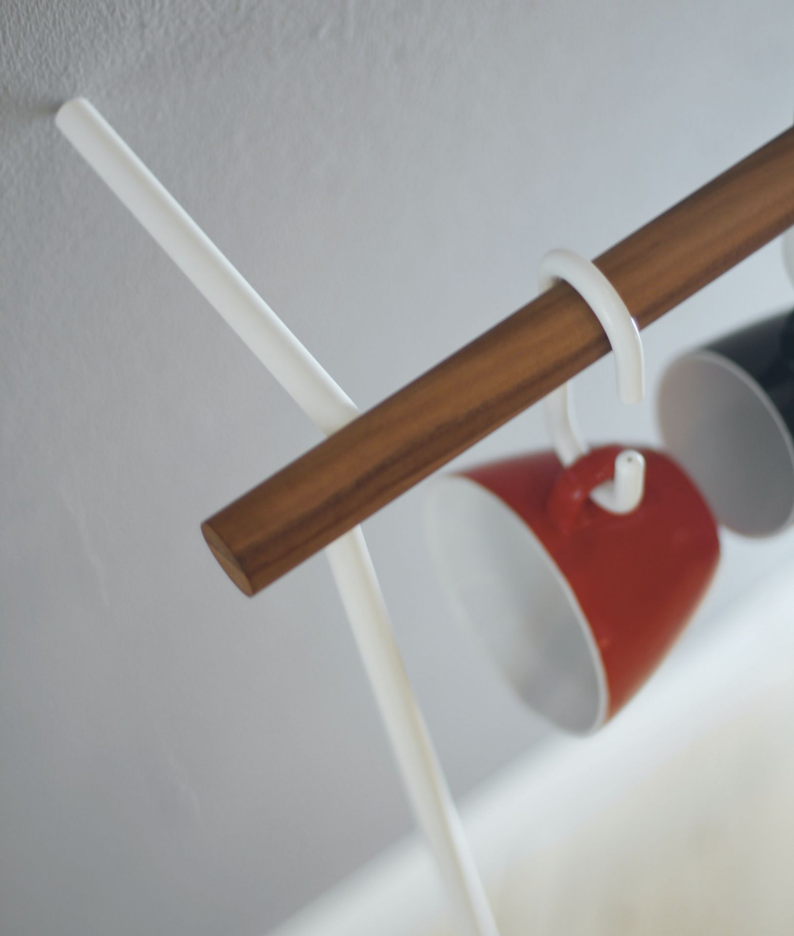 Detailaufnahme: Little Leanon II Stummer Diener, weiße Säule mit Holzbalken und farbigen Tassen.