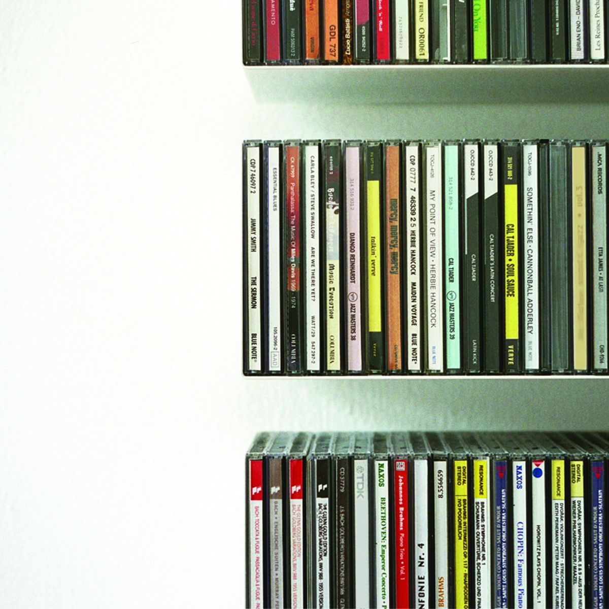 Nahaufnahme von drei weißen CD-Regalen Linea1, gefüllt mit Jazz, Klassik und Blues CDs.