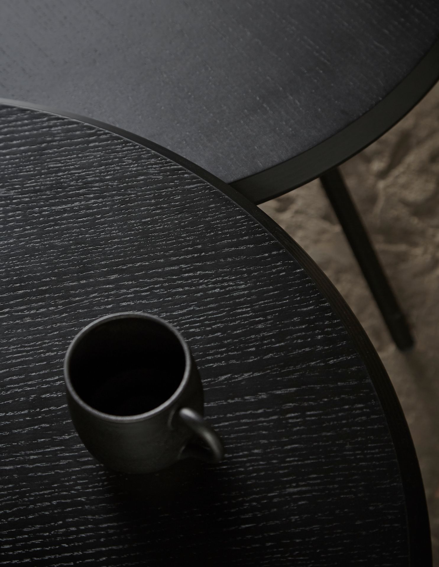 Nahaufnahme des Soround Couchtischs in Anthrazit mit Tasse, modernes Design für Wohnzimmer.