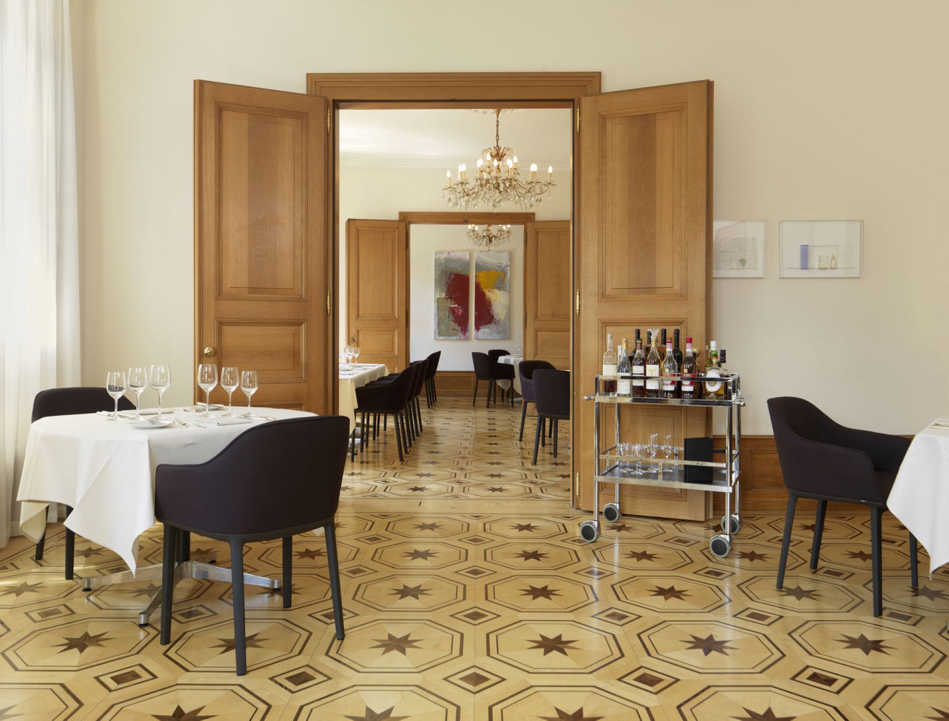 Innenaufnahme eines eleganten Restaurants mit Vitra Softshell Chairs mit Vierfußgestell an gedeckten Tischen.