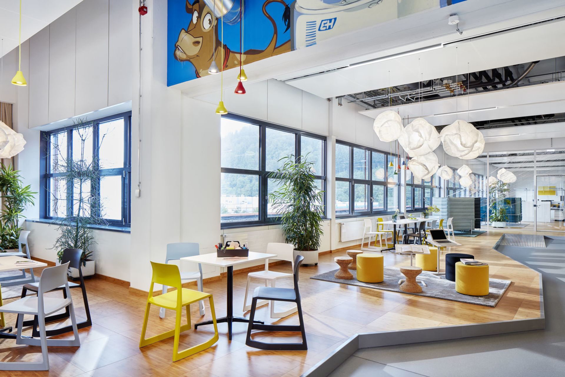 Helles Büro mit mehreren Tip Ton Stühlen von Vitra in Gelb, Grau und Schwarz.