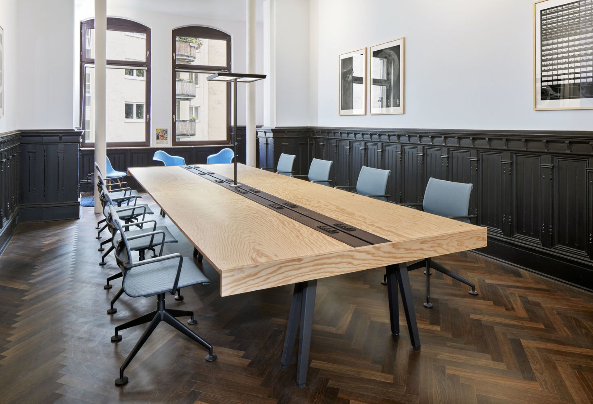 Physix Studio Bürodrehstühle von Vitra um einen großen Holztisch in einem Konferenzraum.