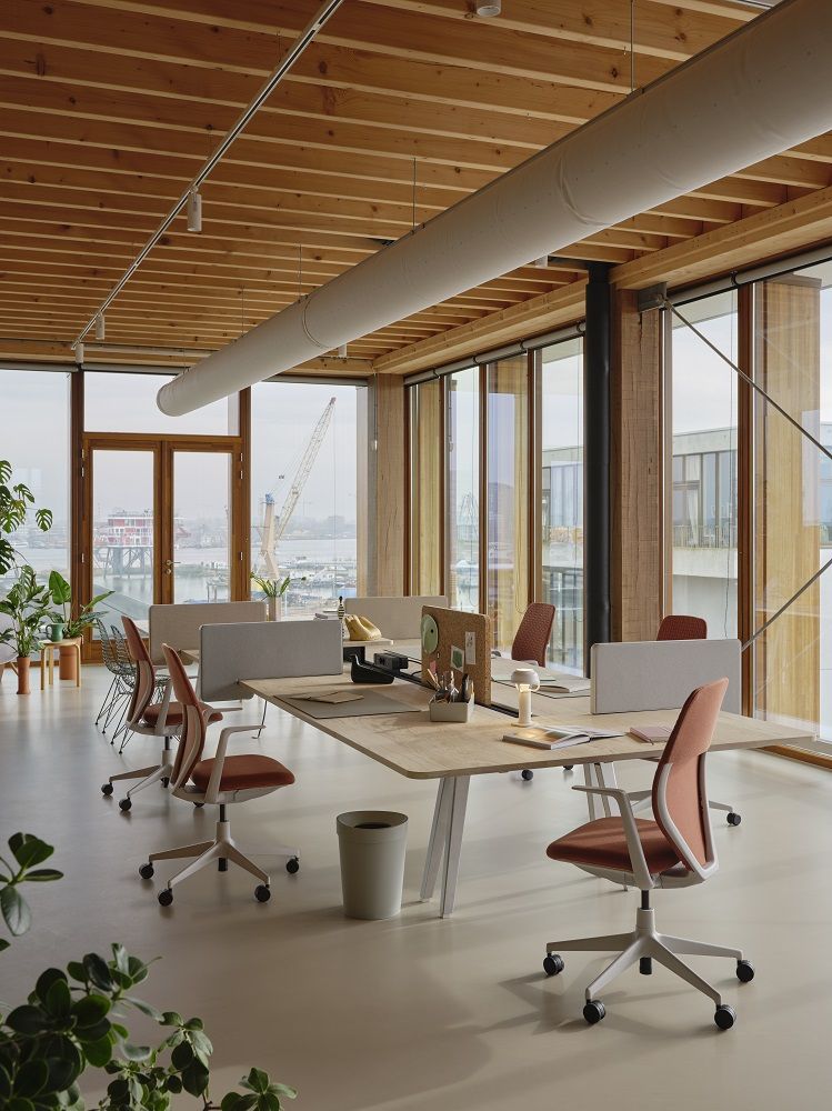 Offene Büroumgebung mit mehreren ACX Soft Bürodrehstühlen von Vitra in Orange und Weiß.