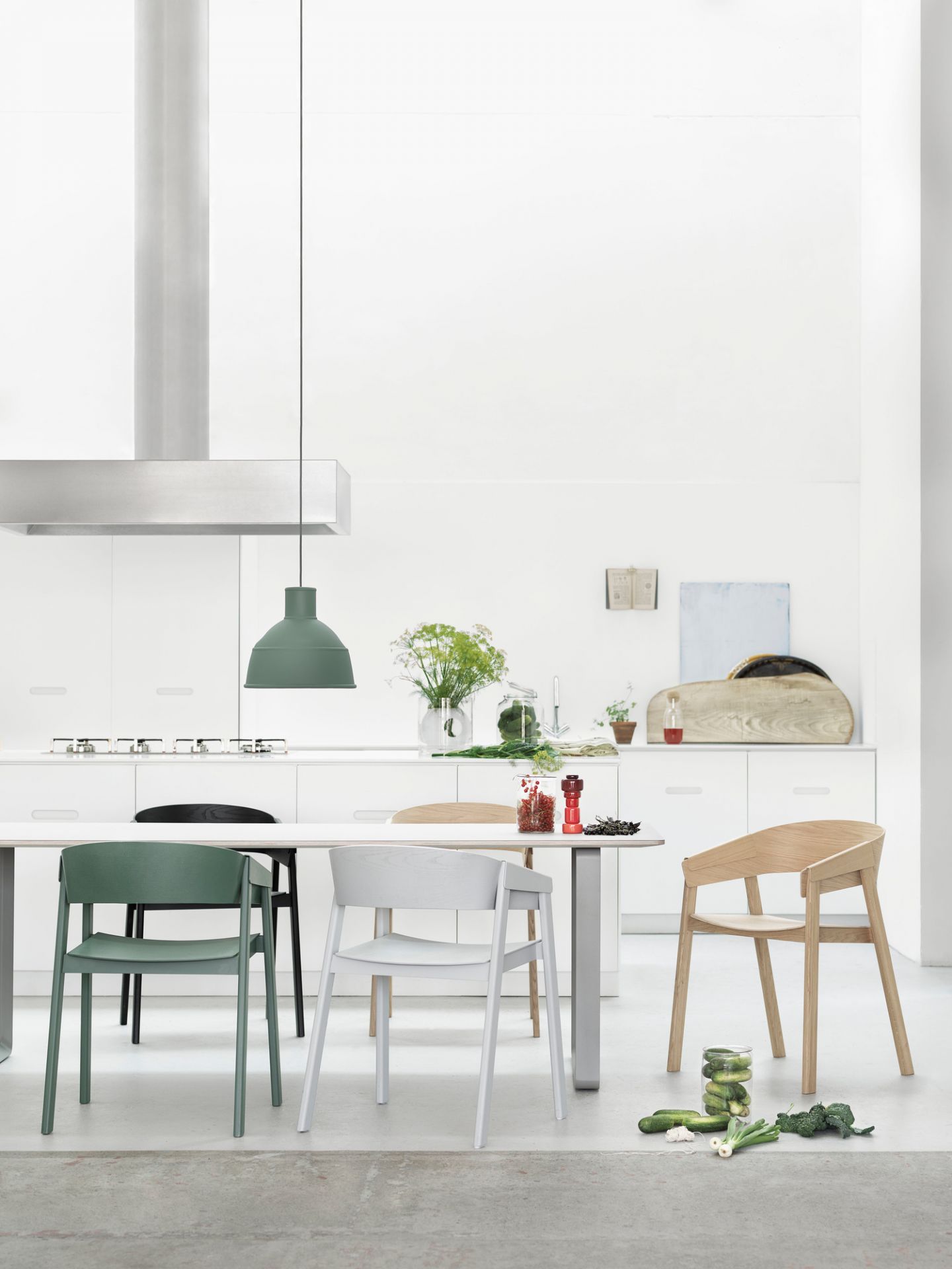 Muuto Cover Chair Stuhl in verschiedenen Farben am Esstisch in einer modernen Küche.
