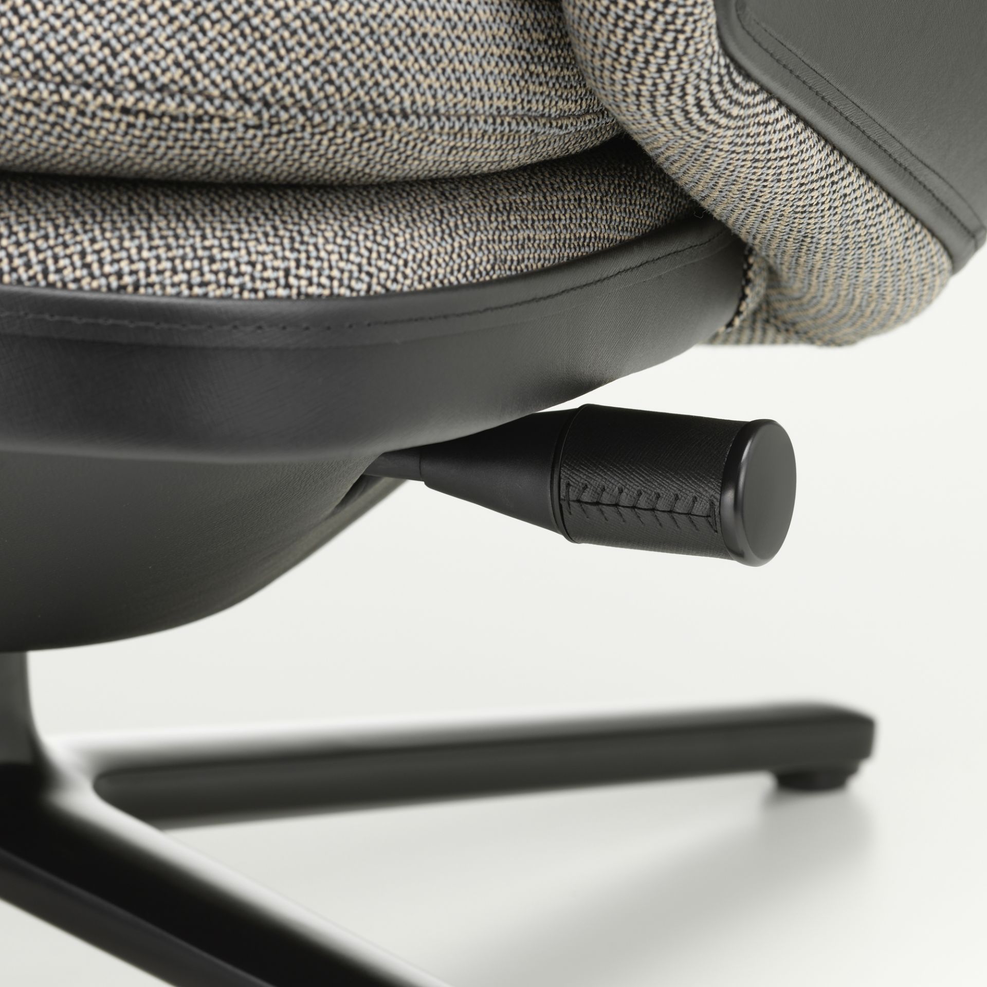 Detailaufnahme des Vitra Grand Relax Sessels: Verstellhebel, Stoffbezug und schwarzes Untergestell.