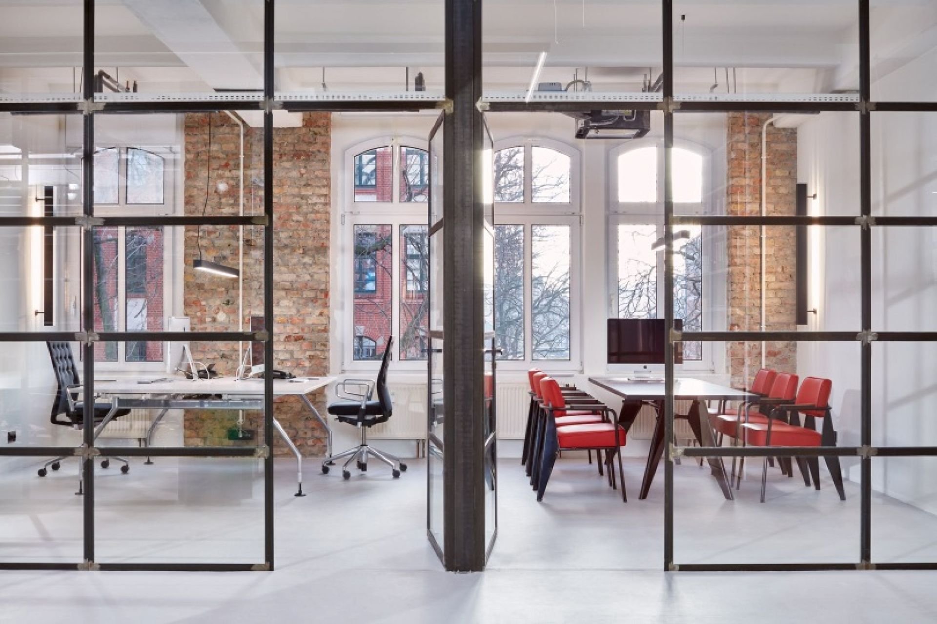 Büro mit Vitra EM Table, einem modernen Tisch mit HPL-Platte, umgeben von Stühlen.