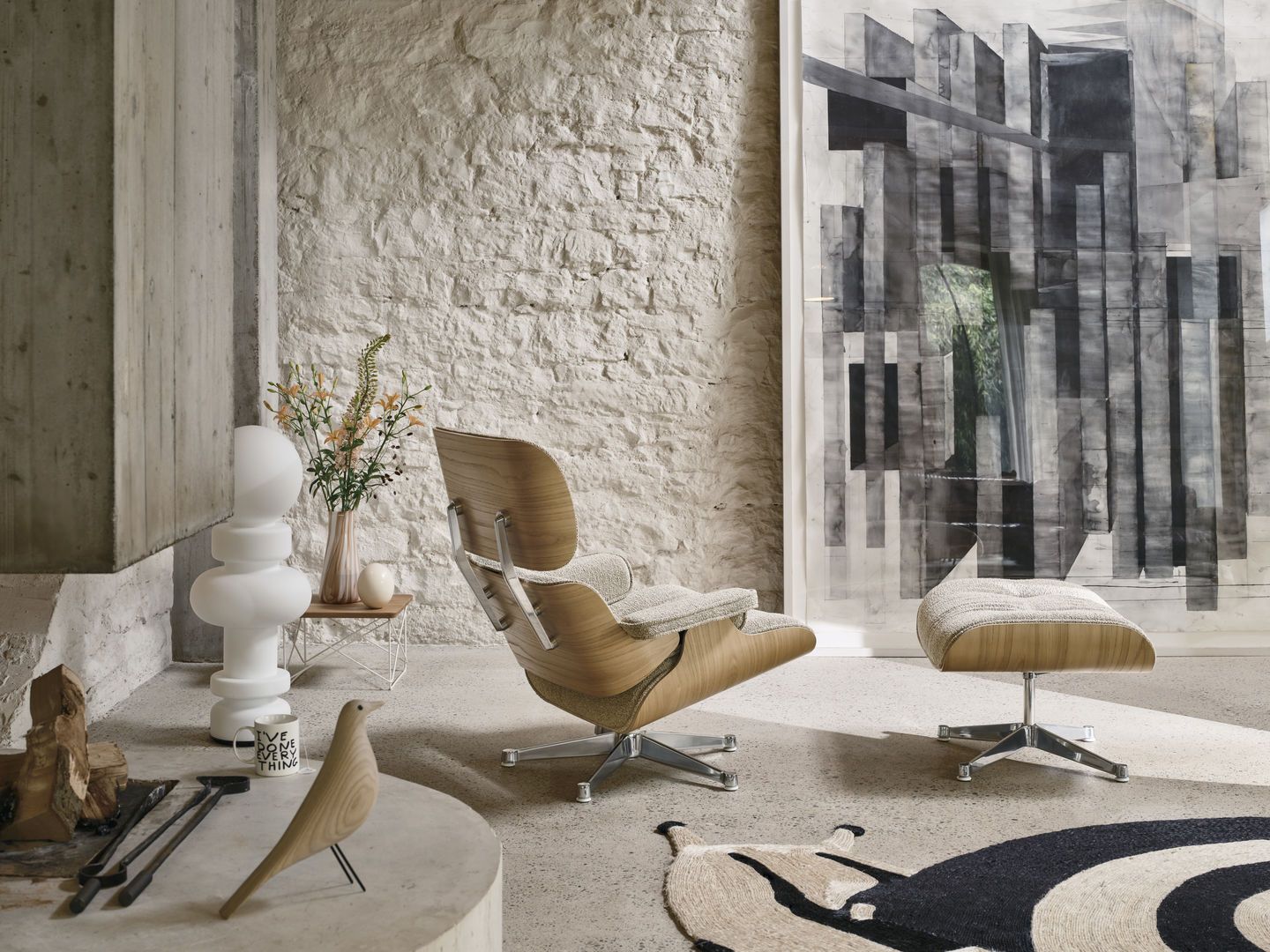 Eames Lounge Chair mit Ottoman von Vitra in hellem Holz und Stoffbezug im modernen Wohnzimmer.